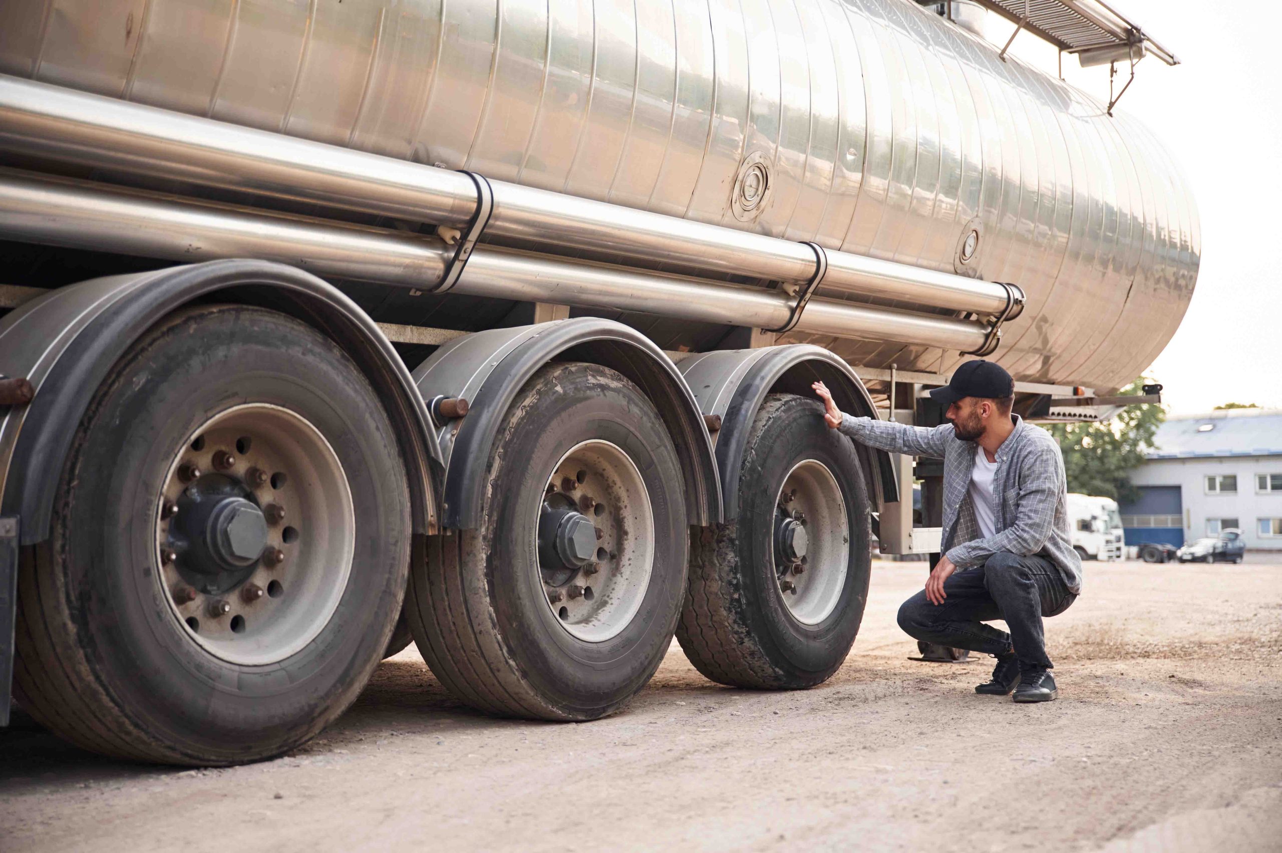 Man inspecting tanker truck tires.